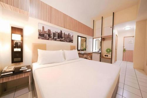 a large white bed in a hotel room at Majestic Hotel Manila - Formerly Octagon Mansion Hotel Manila in Manila