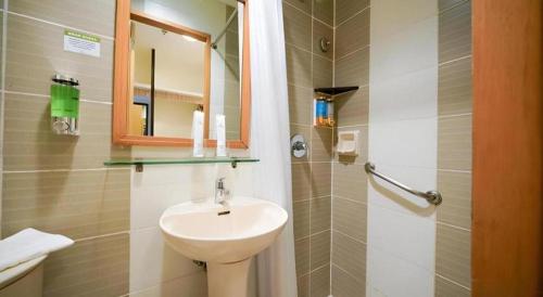 a bathroom with a sink and a mirror and a shower at Majestic Hotel Manila - Formerly Octagon Mansion Hotel Manila in Manila