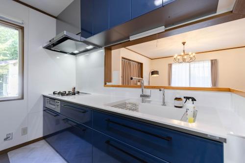 a kitchen with blue cabinets and a sink at N-Stream Old Karuizawa West in Karuizawa