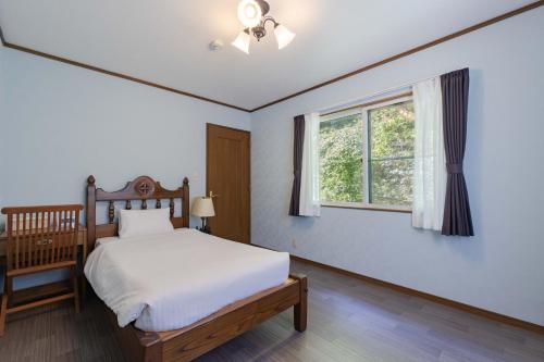 a bedroom with a bed and a window at N-Stream Old Karuizawa West in Karuizawa