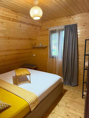 a bedroom with a bed in a wooden cabin at Cozy Home Buknari in Buknari