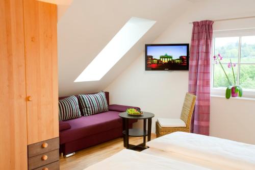 a bedroom with a purple couch and a window at Boutique Hotel Toso Genussreich in Leutschach