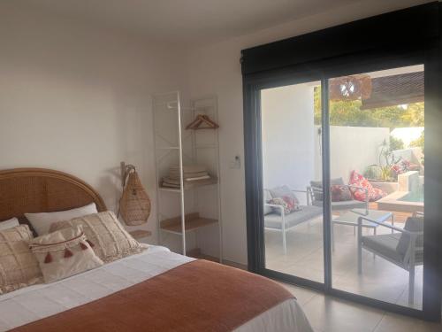 a bedroom with a bed and a sliding glass door at Case Ylang Blossom in Étang-Salé