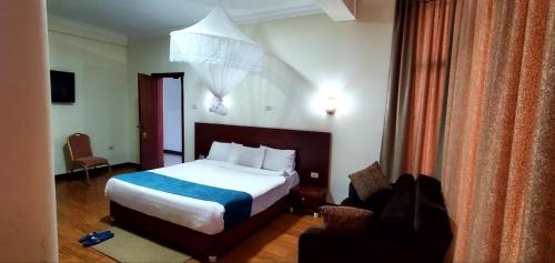 a hotel room with a bed and a chair at Yiganda Hotel, Ethiopia in Bahir Dar