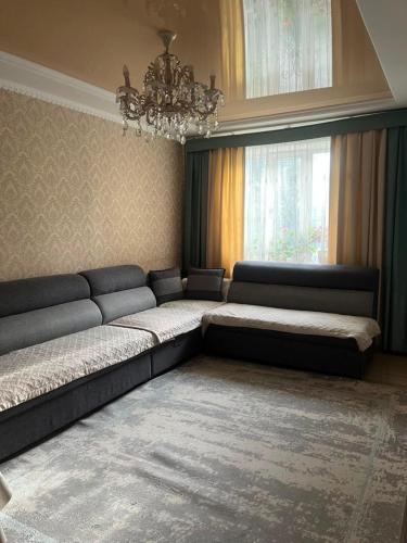 a living room with two beds and a chandelier at Camp&CO in Naryn
