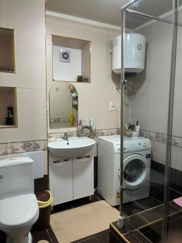 a bathroom with a washing machine and a sink at Camp&CO in Naryn