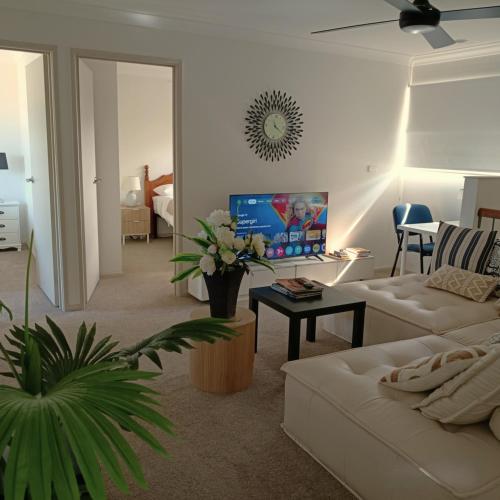 a living room with a couch and a table at "Casa Serena" - Spacious Entire Holiday Home in Caboolture