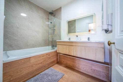 a bathroom with a tub and a sink and a mirror at Le Chagnotin in Chagny