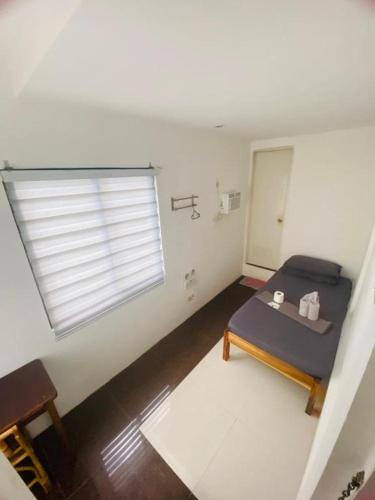 a small room with a bed and a window at Raje Residence El Nido in El Nido