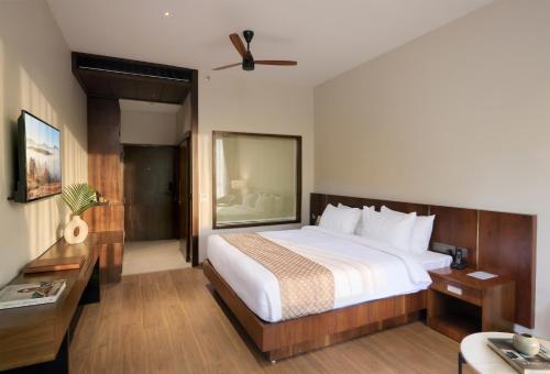 a hotel room with a bed and a desk at Surya Grand Hotel in Kalpetta