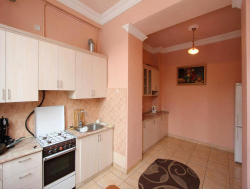 a kitchen with white cabinets and a sink at Apartment by Opera in Yerevan