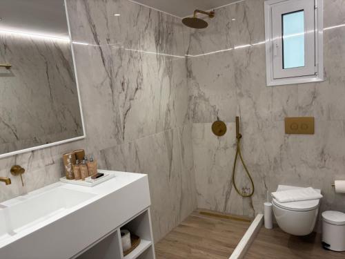 a bathroom with a sink and a toilet and a mirror at White Rose Athens Residence in Athens