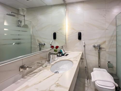 a bathroom with a sink and a toilet and a mirror at Bosphorus Hotel Grand Safi in Medina