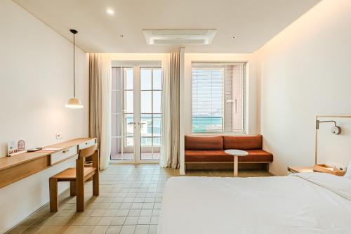 a bedroom with a bed and a desk and a chair at 콘스트호텔 in Hyŏpchae-ri