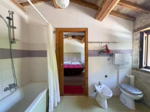 a bathroom with a tub and a toilet and a sink at B&B Mulini Venturi in Saludecio