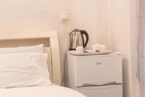 a tea kettle on a night stand next to a bed at Faafu View Maldives in Maldive Islands
