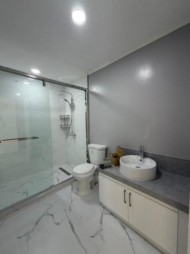 a bathroom with a toilet and a sink and a shower at Beachfront House in Garapan