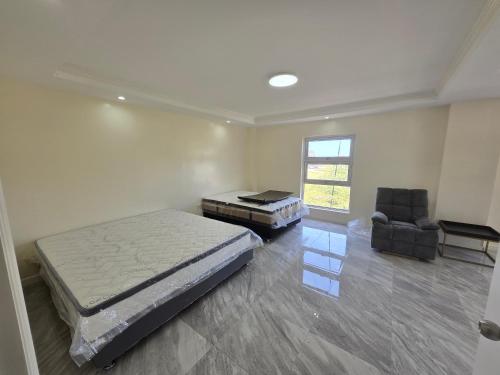 a bedroom with a bed and a desk and a chair at Beachfront House in Garapan