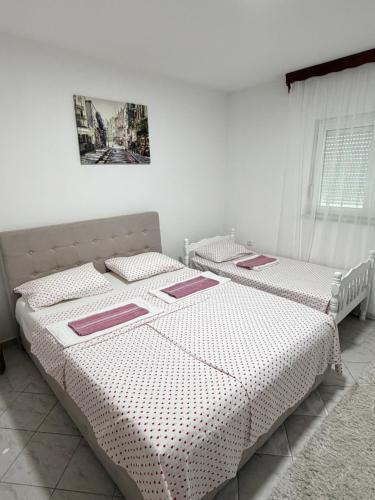 two beds sitting next to each other in a bedroom at Apartments Ana - Airport shuttle option in Podgorica
