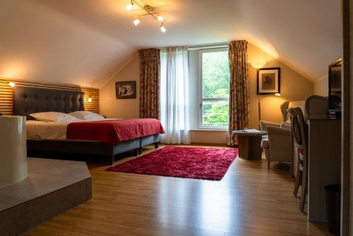 a bedroom with a bed and a large window at Moulin de Daverdisse in Daverdisse