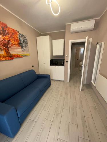 a living room with a blue couch and a kitchen at Blue Inn Residence e B&B in Lido delle Nazioni