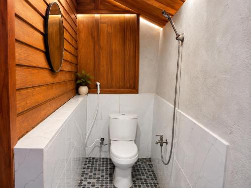 a bathroom with a toilet and a shower at Wavez Bungalow in Selong Belanak