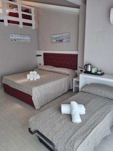a bedroom with two beds with towels on them at Blue Inn Residence e B&B in Lido delle Nazioni