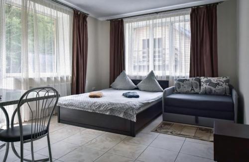 a bedroom with a bed and a chair and windows at Rika House in Sinyak