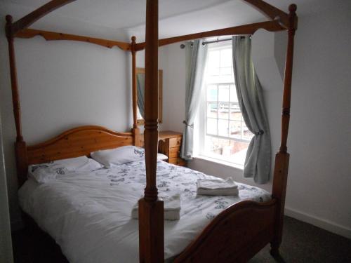 a bedroom with a canopy bed and a window at Yarm View Cottages in Yarm