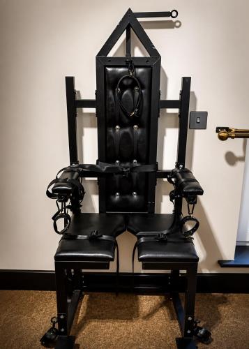a black chair sitting in front of a wall at Casa Amor - Adult Only Jacuzzi Suite in Southampton