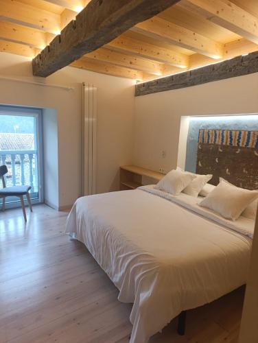 a bedroom with a large white bed with a wooden ceiling at Benaki 92B in Ladines