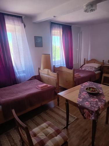 a small room with two beds and a table and a table sidx sidx at Zimmer A Veljanovski in Blaufelden