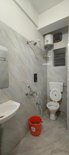 a bathroom with a white toilet and a sink at M A P Hotel in Nager Bazaar