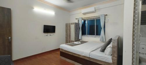 a bedroom with a bed and a tv on the wall at M A P Hotel in Nager Bazaar