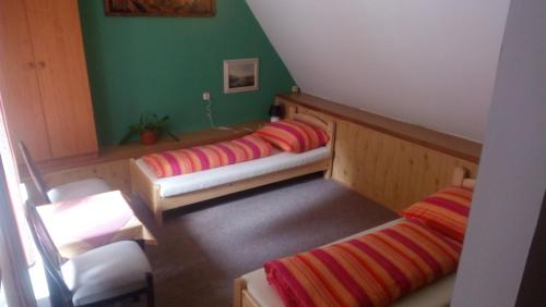 two beds in a room with green walls at Pension Rybářská Bašta in Rožmberk nad Vltavou