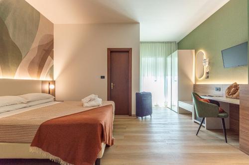 a hotel room with a bed and a desk at Hotel Terme Paradiso in Abano Terme
