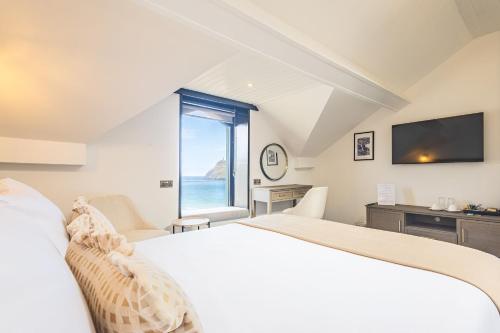 a bedroom with a large bed and a large window at Falcon's Nest Hotel in Port Erin