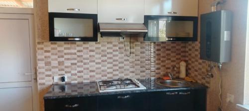 a small kitchen with a stove and a sink at Ancient Lahij Guest House in Lahıc