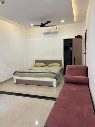 a bedroom with a bed and a ceiling fan at GRAYSTONE HOMESTAY, Omassery in Tāzhekkod