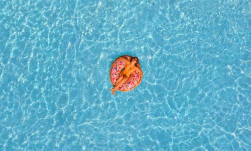 a person in the water with a donut in the water at Cretan Breeze Villa Heated Pool in Dhrámia