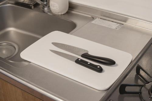 a knife on a white cutting board on a sink at Numazu Royal Retreat 201 in Numazu