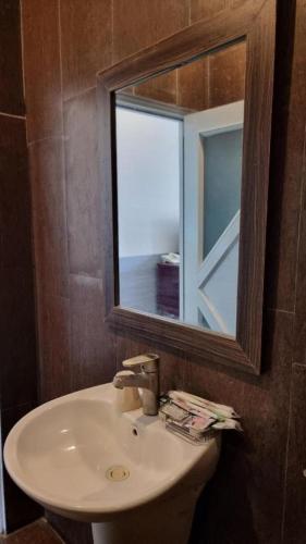 a bathroom with a sink and a mirror at RUBY HOTEL in Cà Mau