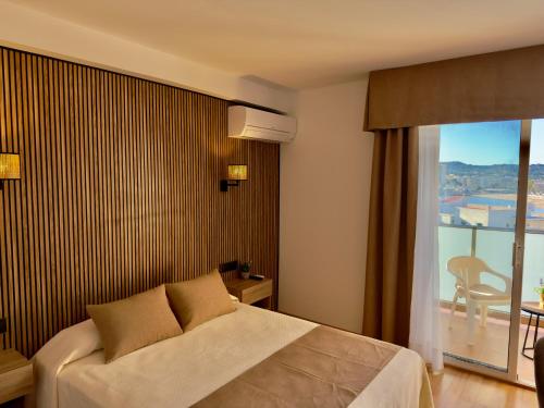 a hotel room with a bed and a balcony at Hotel Villa Naranjos in Jávea