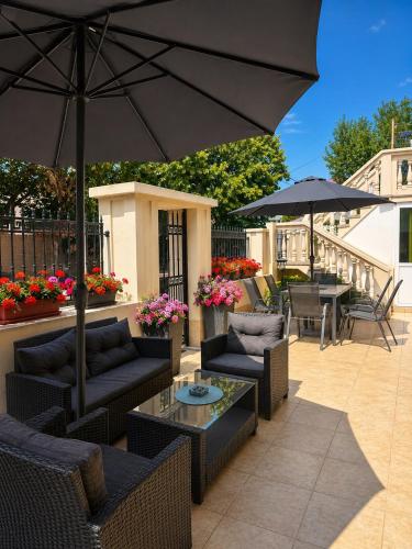 a patio with chairs and tables and an umbrella at Guestrooms Zoya in Chernomorets
