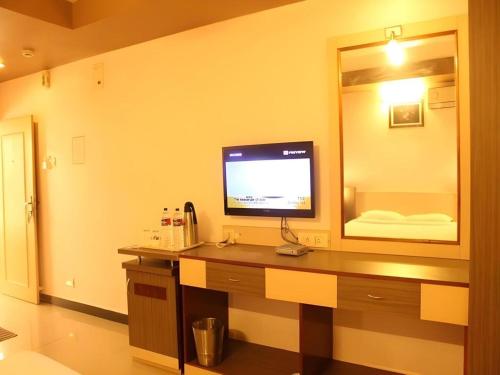 a room with a desk with a television on it at Hotel Colva Kinara in Colva