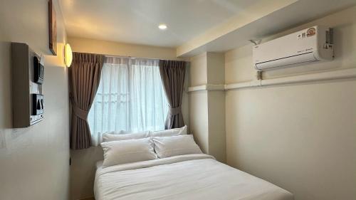 a small room with a bed with a window at April Ari-Saphankhwai in Bangkok