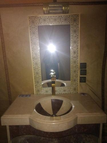 a person taking a picture of a sink in a bathroom at Merzouga camelle trike bivoage in Merzouga