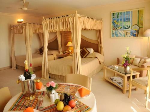 a bedroom with two beds and a table with fruit on a table at Ohris Baseraa in Hyderabad