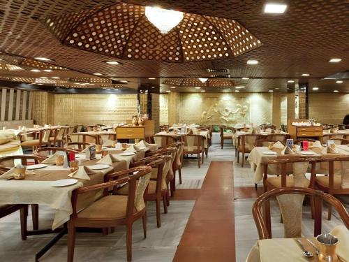 a dining room with tables and chairs in a restaurant at Ohris Baseraa in Hyderabad