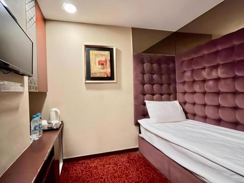 ein Schlafzimmer mit einem großen Bett mit gepolstertem Kopfteil in der Unterkunft Oriental Lander Hotel in Hongkong
